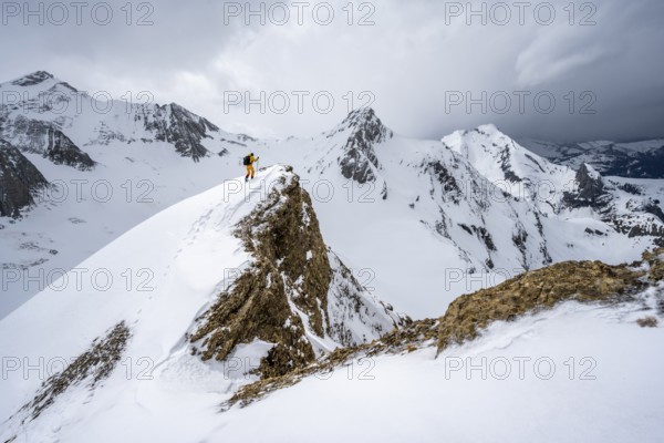 Ski tourers climbing the Niesehorn, Wildhorn summit behind, snow-covered mountain landscape,