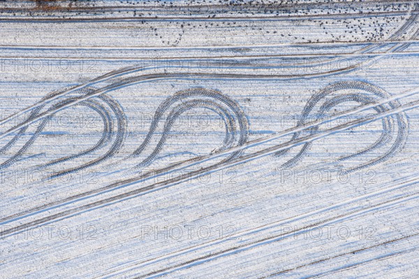 Aerial view tractor tracks on a snowy field, winter, curve, turn, agriculture, Lower Saxony,