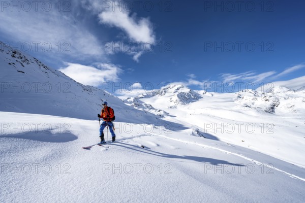 Ski tourers in a snow-covered mountain landscape, mountain peak Monte Cevedale and glacier