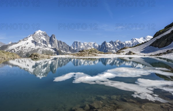 Mountain landscape with mountain lake and ice floe, water reflection in Lac Blanc, mountain peak,