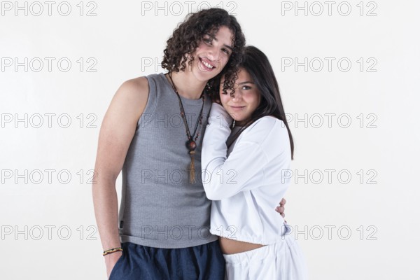Portrait of a young couple dressed in yoga clothes looking ti the camera white background. Studio