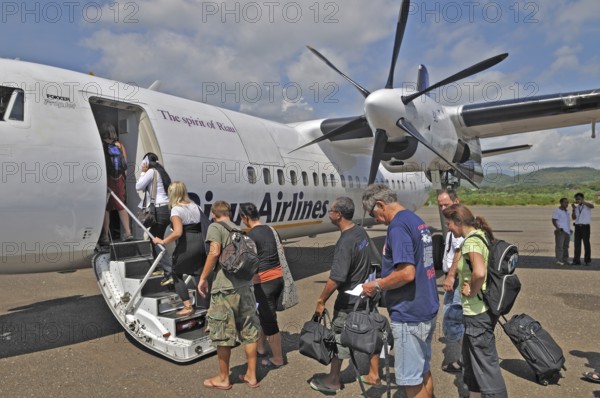 Propeller aircraft, prop jet Fokker 50, former Riau Airlines, passengers at the airport in Labuan