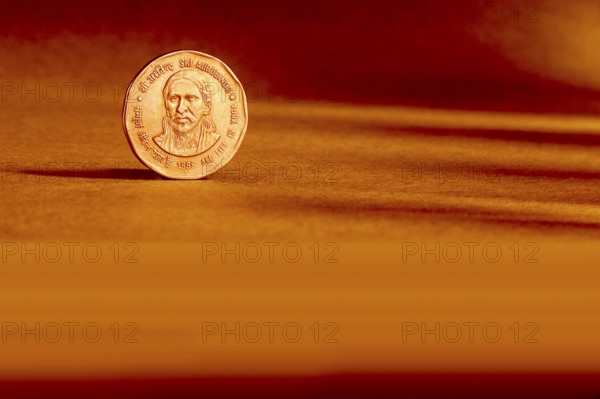 One Indian currency two rupees coin backside embossed Sri Aurbindo all life is yoga 1998 on orange