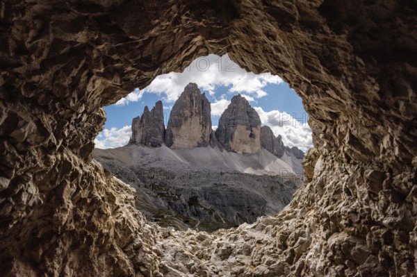 View out of an old tunnel window towards the iconic Three Peaks mountain in the Dolomite Alps,