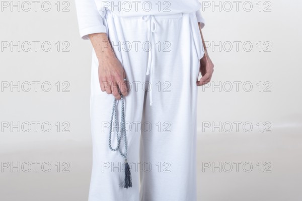 Close up of a hand holding a japa mala over white background. Studio shot