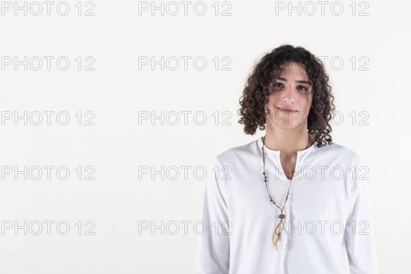 Portrait of a young man dressed in white yoga clothes over white background while looking at camera