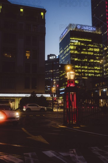 Night city view with illuminated buildings and a passing car, urban lighting, new zealand stock