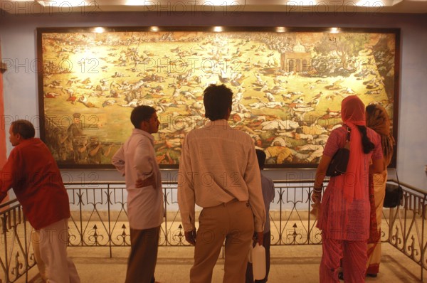 Visitors at the Jallianwala Bagh memorial in Amritsar in Punjab, India have a look at the huge