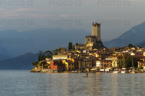 Scaliger castle and city malchesine at sunset with stand up paddle