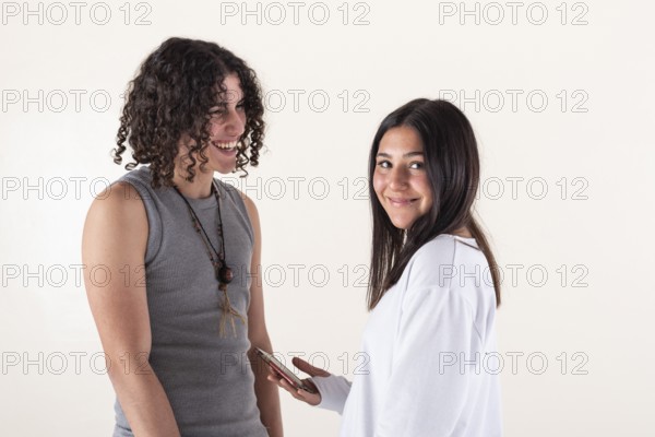 Portrait of a young couple dressed in yoga clothes laughing over white background. Studio shot