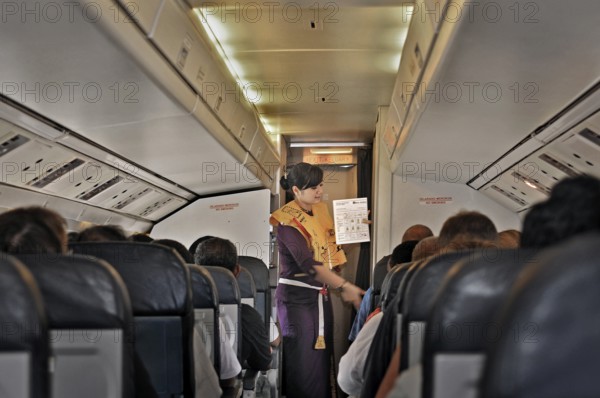 Flight attendant, obsolete stewardess explaining the function of the life jacket, propeller