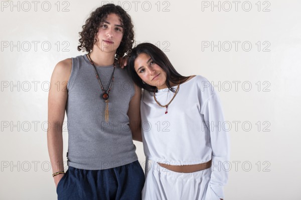 Portrait of a young couple dressed in yoga clothes looking ti the camera white background. Studio