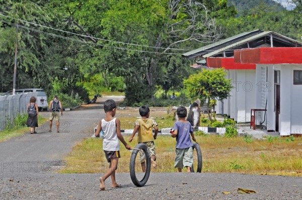 Children playing with tyres, Labuan Bajo, Flores Island, Indonesia, Asia
