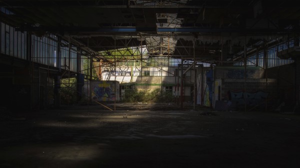 Dark abandoned factory building with light beam and graffiti, Gerresheimer Germany, Lost Place,