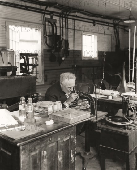 Thomas Alva Edison examining a phonograph disc under a microscope, digitally edited