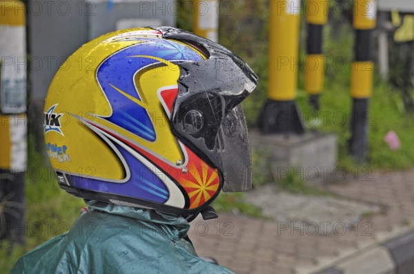 Brightly coloured motorbike shirt in the rain near Ubud, Bali, Indonesia, Asia