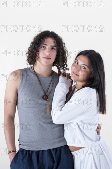 Portrait of a young couple dressed in yoga clothes looking ti the camera white background. Studio
