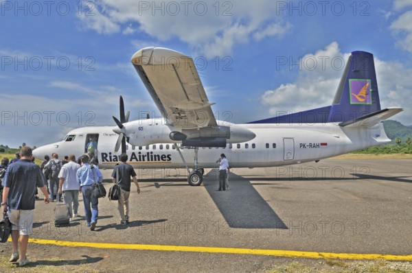 Propeller aircraft, prop jet Fokker 50, former Riau Airlines, passengers at the airport in Labuan