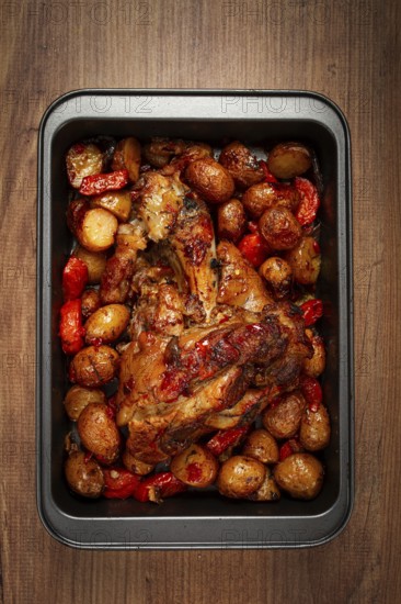 Pork knuckle, baked with vegetables, new potatoes, on a baking sheet, homemade, no people