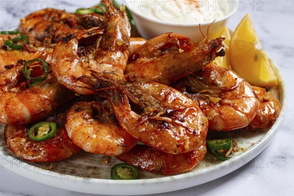Grilled shrimps served with hot sauce and slices of fresh lemon, homemade, no people