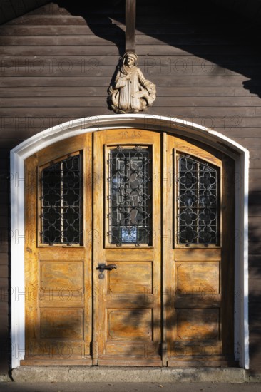 Portal, entrance door, wooden door of the Meinrad Chapel built in 1948 in the princely park of