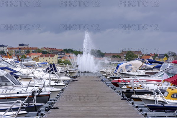 Boat mooring with boats in front of the island of Stakholmen with a view of the water fountain in