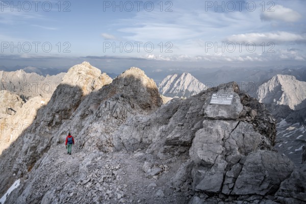 Mountaineer on a ridge, jubilee ridge in the evening light, sign, signpost, steep rocky mountain