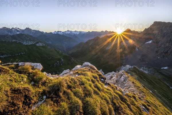 Mountain landscape at sunrise with sun star, view of mountain peaks of the Venediger group and into