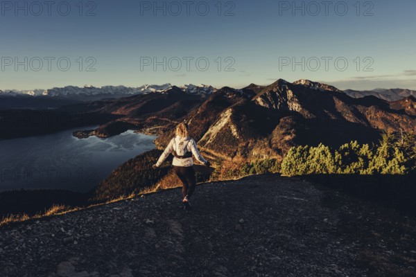 Trail running in autumn on the Jochberg on Lake Walchensee against the wonderful backdrop of the
