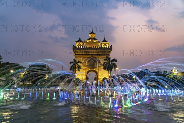 Colourfully illuminated fountain at Patuxai Victory Gate at dusk, capital Vientiane, Laos, Asia