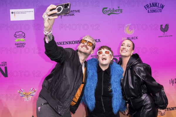 Guests take selfies on the red carpet in front of the Polyton 2024 award ceremony in Berlin's