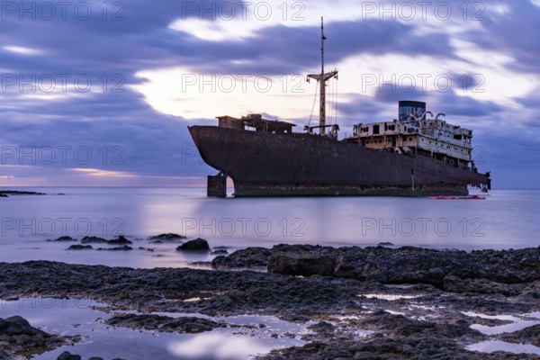 Lost Place, Ghost Ship, Rusty hull on calm water at sunset, Canary Islands, Lanzarote, Spain,