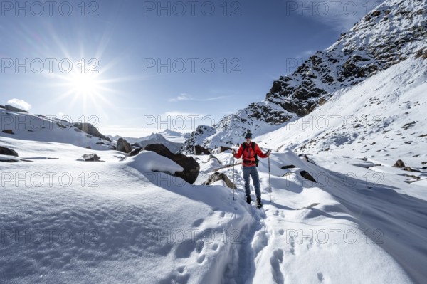Mountaineer on a hiking trail with snow on the Ramoljoch, behind mountain Ramolkogel, Sonnenstern,