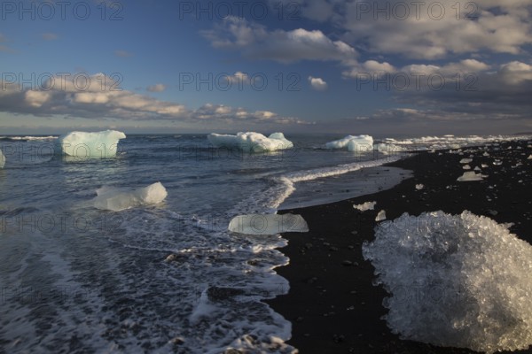 Little icebergs and crushed ice on the black beach at Joekulsarlon glacial lake