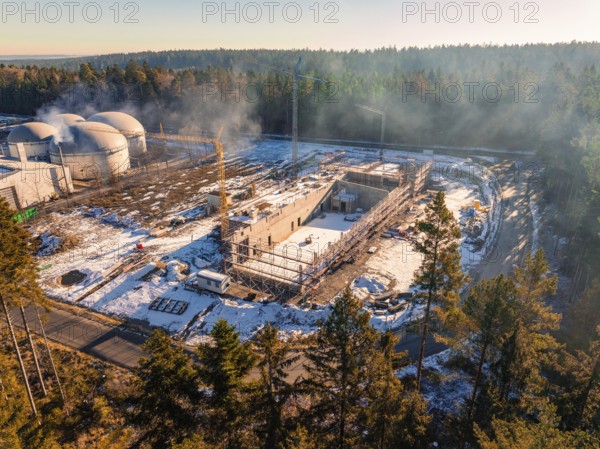 Construction site near domed buildings in the forest, snow-covered and with construction crane, new