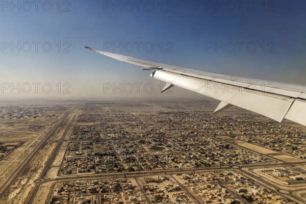 Landing approach over the desert to Abu Dhabi with the airline Etihad. View from the window of a