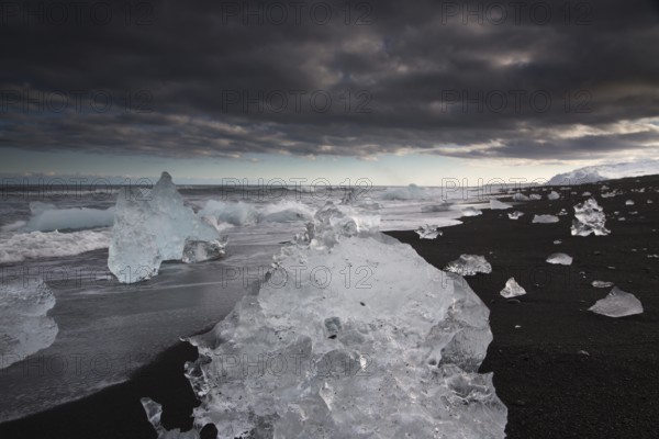 Little icebergs and crushed ice on the black beach at Joekulsarlon glacial lake