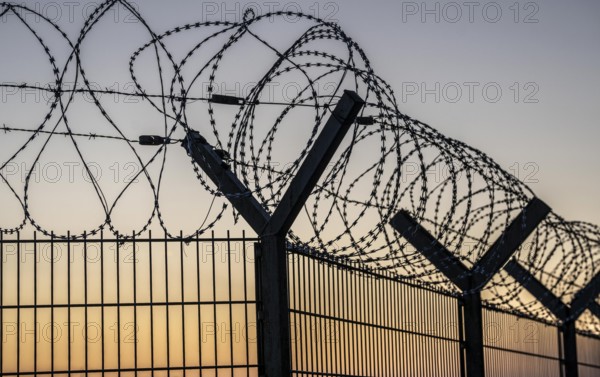 Symbolic image security, S-wire rolls, NATO wire, on a fence top, demarcation of a property,