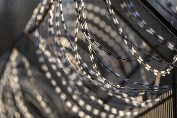 Symbolic image security, S-wire rolls, NATO wire, on a fence top, demarcation of a property,