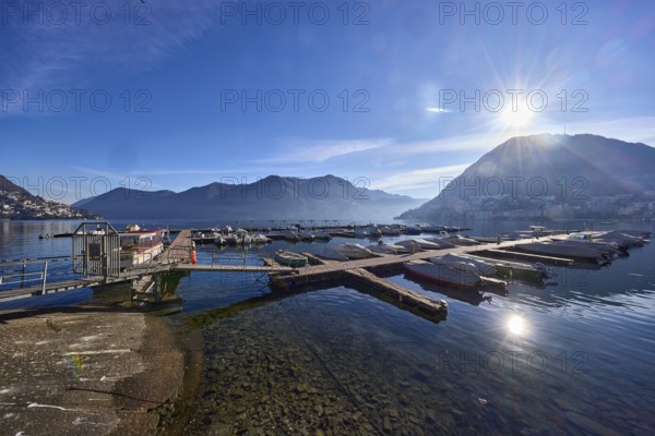 Marina, motorboats, lake, mountains, haze, backlight of the sun, blue sky with veil clouds, Lake