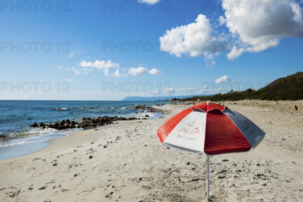 Lonely beach and parasol, Spiaggia di Biderosa, Riserva Biderosa nature reserve, Orosei, Nuoro