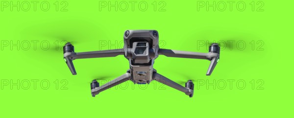 Isolated unmanned aircraft system (UAV) quadcopter drone in the air over A green screen