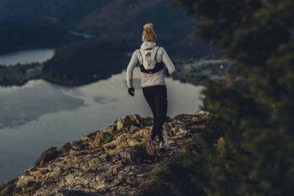 Trail running in autumn on the Jochberg on Lake Walchensee against the wonderful backdrop of the