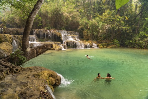 Tourists bathing in the Kuang Si waterfall near Luang Prabang, Laos, Asia
