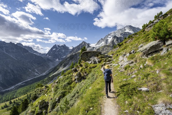 Mountaineer on a hiking trail, mountain landscape near Arolla, behind mountain peak Mont Collon and