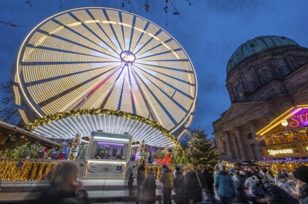 Ferris wheel at the winter village, Christmas market at dusk, St Elisabeth's Church on the right,