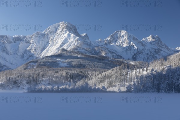 Lake Almsee frozen and snowcovered with the Totes Gebirge mountains in the background