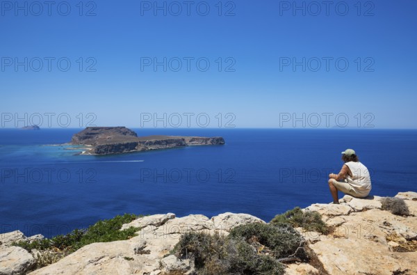 Hikers on the way to the cape of the Gramvousa peninsula with a view of the island of Imeri