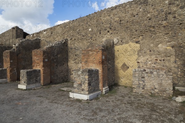 Remnants of old terracotta brick and stone wall structure plus numbered columns with white marble
