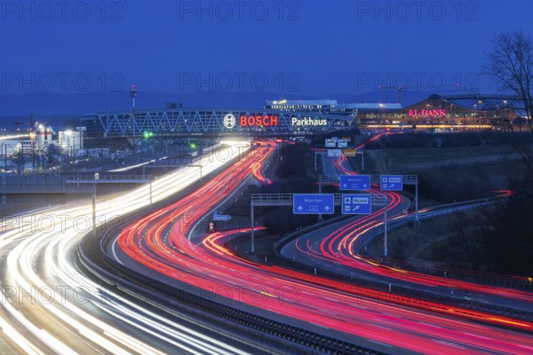 A8 motorway at Stuttgart Airport in the evening. Heavy traffic, lanes of light. Modern architecture
